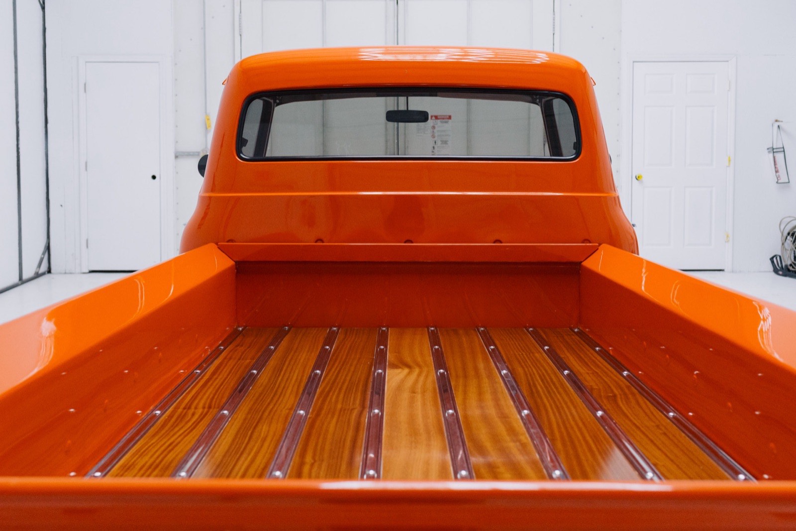 1956 Ford F-100 stepside in vibrant orange, restored by Morgan Muscle Cars in Pelham, Alabama