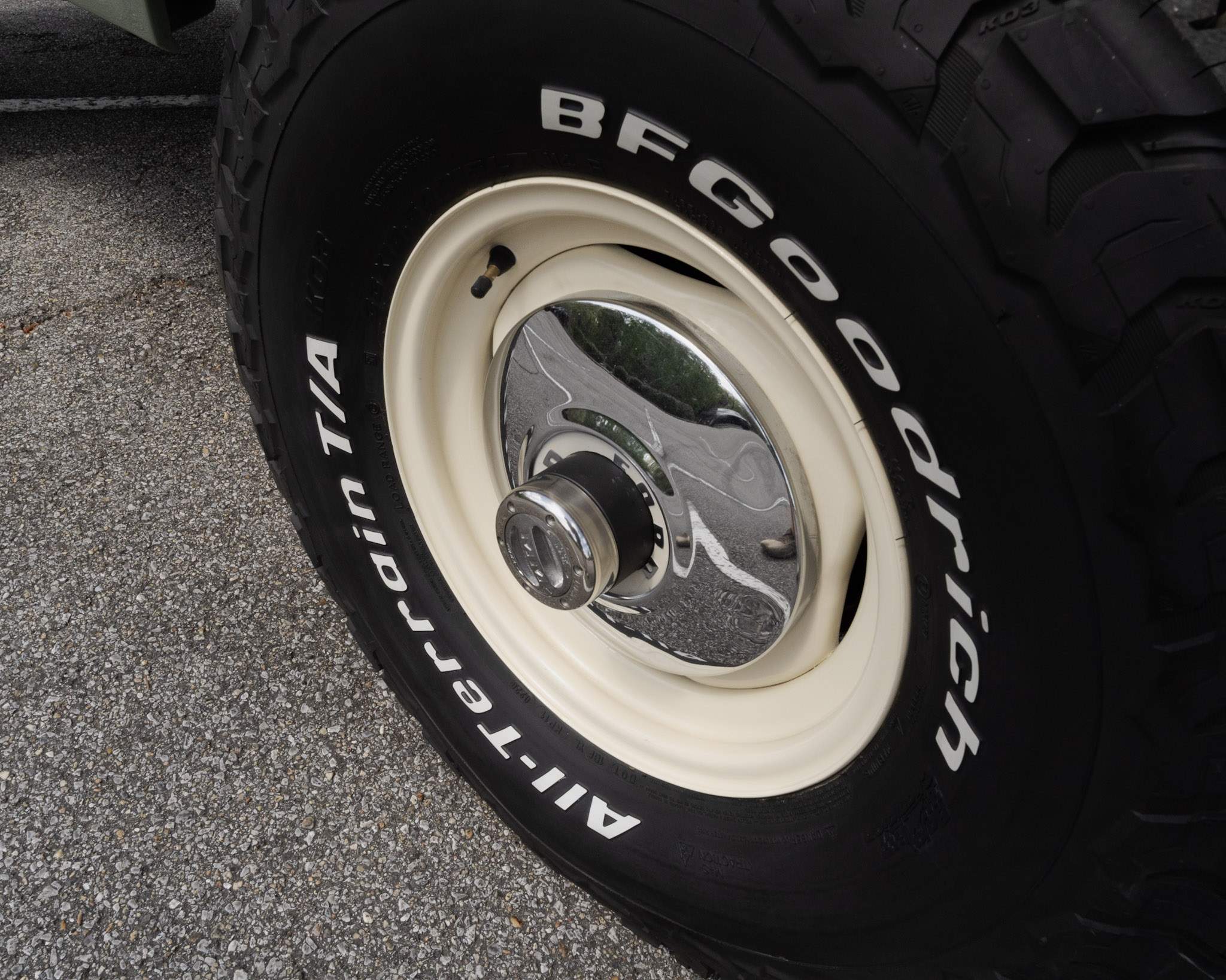 1967 Ford Bronco cream wheel with a vintage Ford hubcap and 33-inch BFGoodrich All-Terrain tire — Morgan Muscle Cars in Pelham, Alabama
